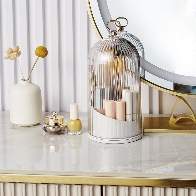 Decorative items on a table including a glass dome, candles, and a vase.