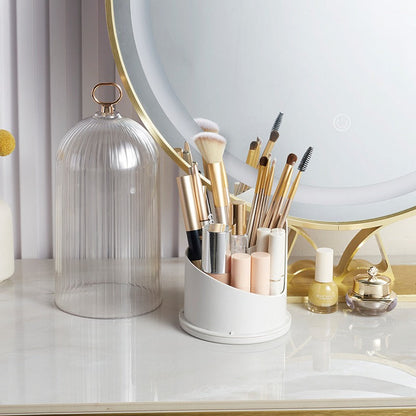 Makeup brushes and products on a vanity with a round mirror.