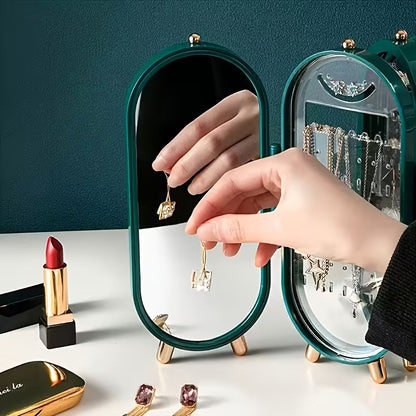 Person trying on earrings in front of a compact mirror with jewelry and lipstick visible.