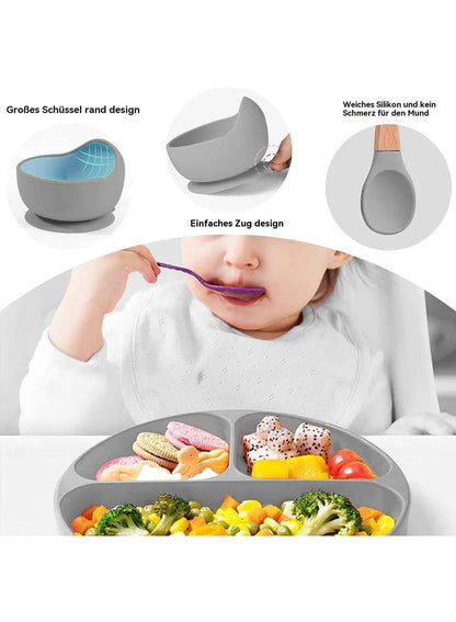 Child using a silicone spoon with a gray bowl and plate set on a white background
